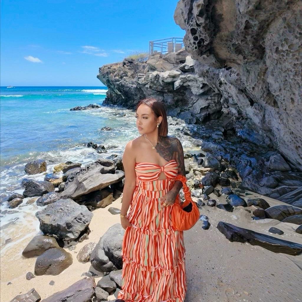 Femme portant un ensemble jupe longue orange à motifs multicolores avec haut assorti sans manches