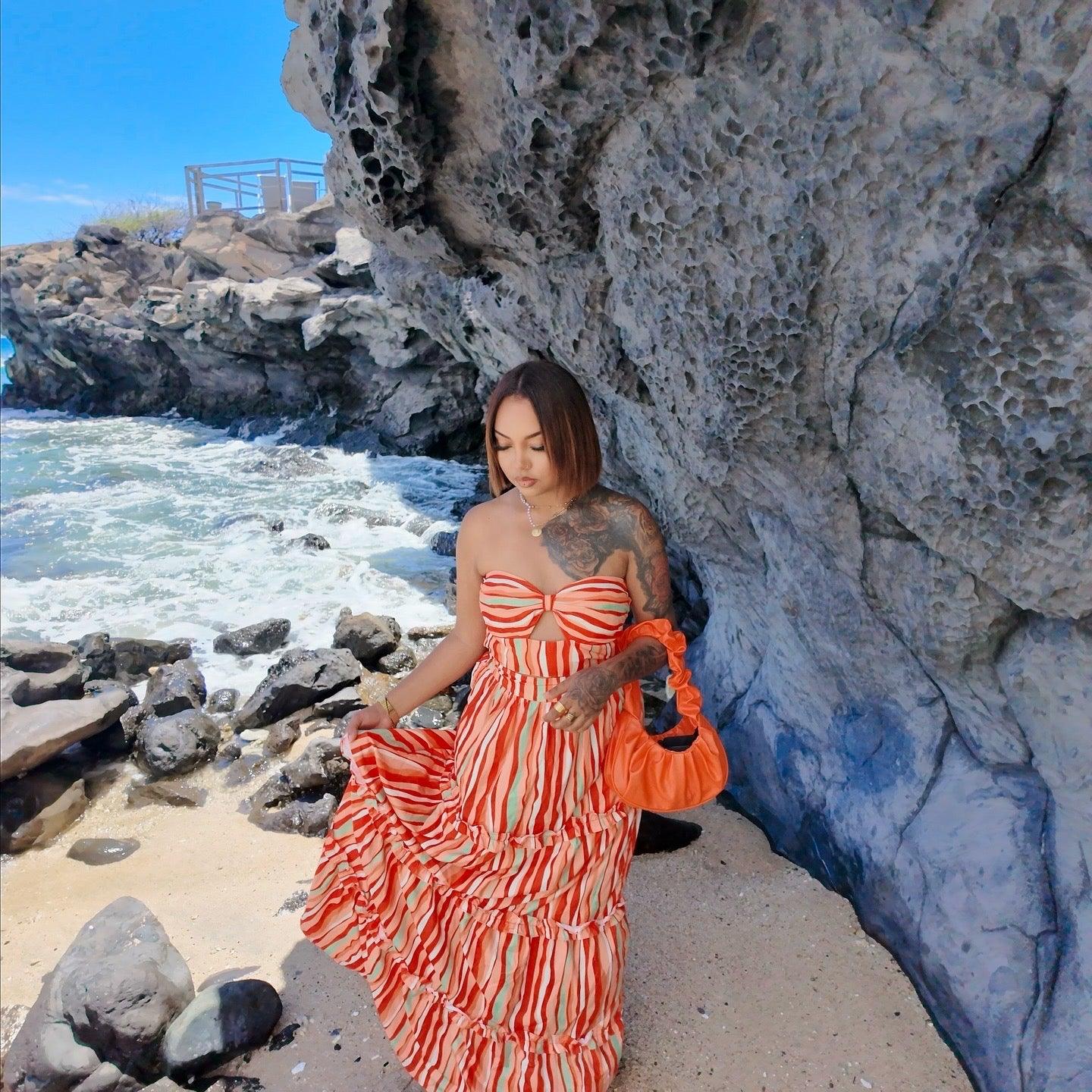 Femme portant un ensemble jupe longue orange à motifs multicolores avec haut assorti sans manches