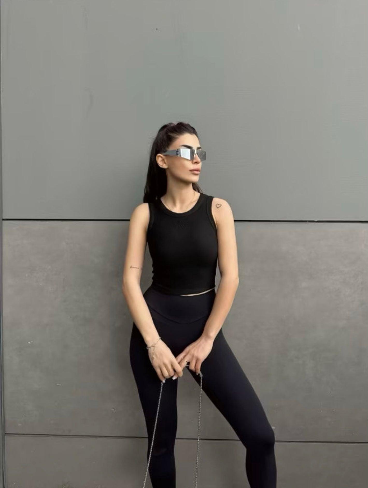Top noir col halter en maille côtelée porté par une femme (modèle Haut Nilya)