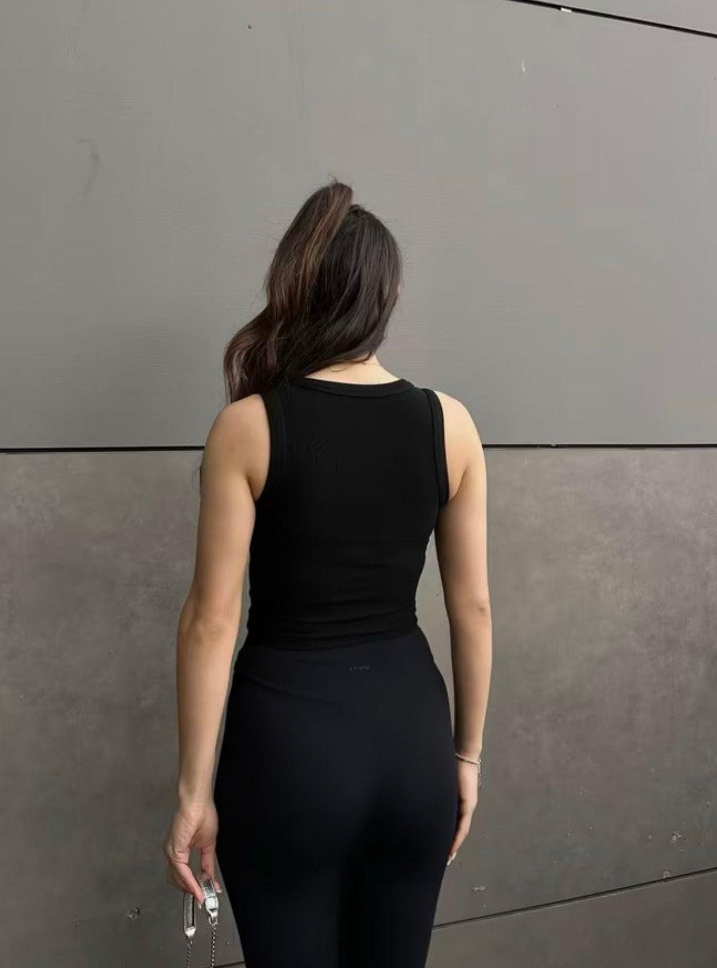 Top noir col halter en maille côtelée porté par une femme (modèle Haut Nilya)