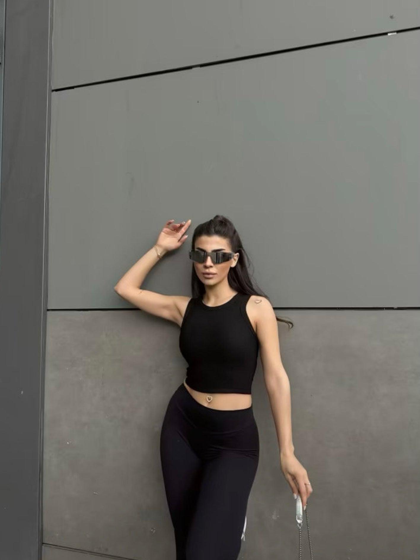 Top noir col halter en maille côtelée porté par une femme (modèle Haut Nilya)