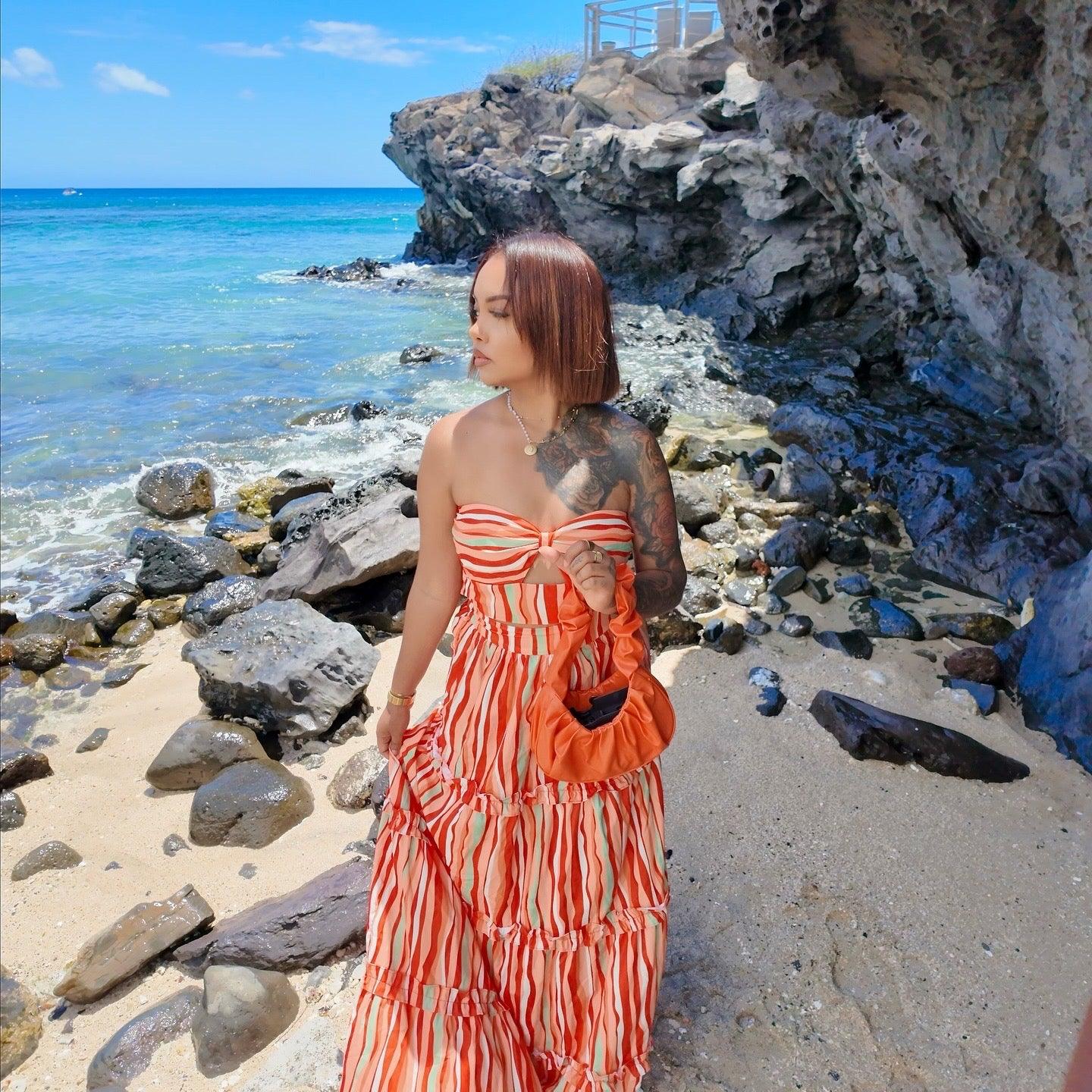 Femme portant un ensemble jupe longue orange à motifs multicolores avec haut assorti sans manches
