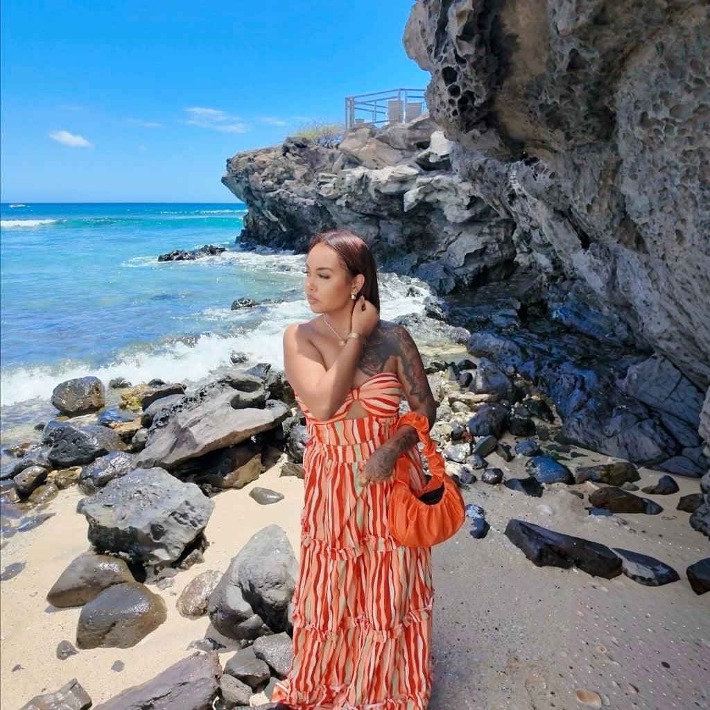 Femme portant un ensemble jupe longue orange à motifs multicolores avec haut assorti sans manches
