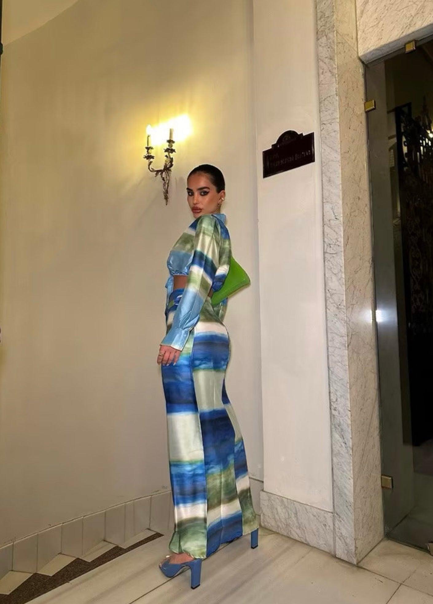 Femme portant un ensemble veste nouée bleu-vert et jupe midi fendue assortie