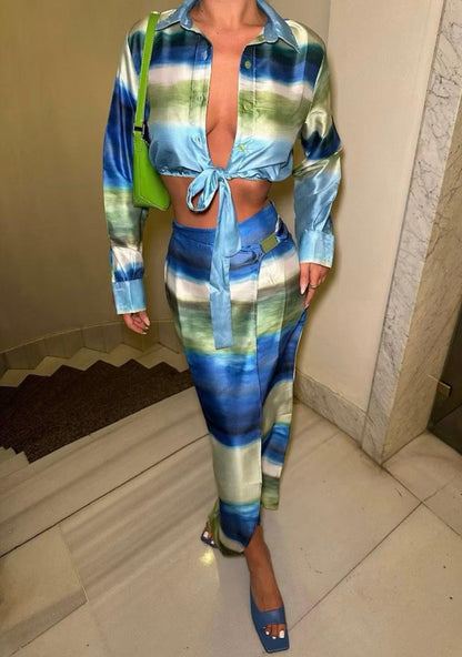 Femme portant un ensemble veste nouée bleu-vert et jupe midi fendue assortie