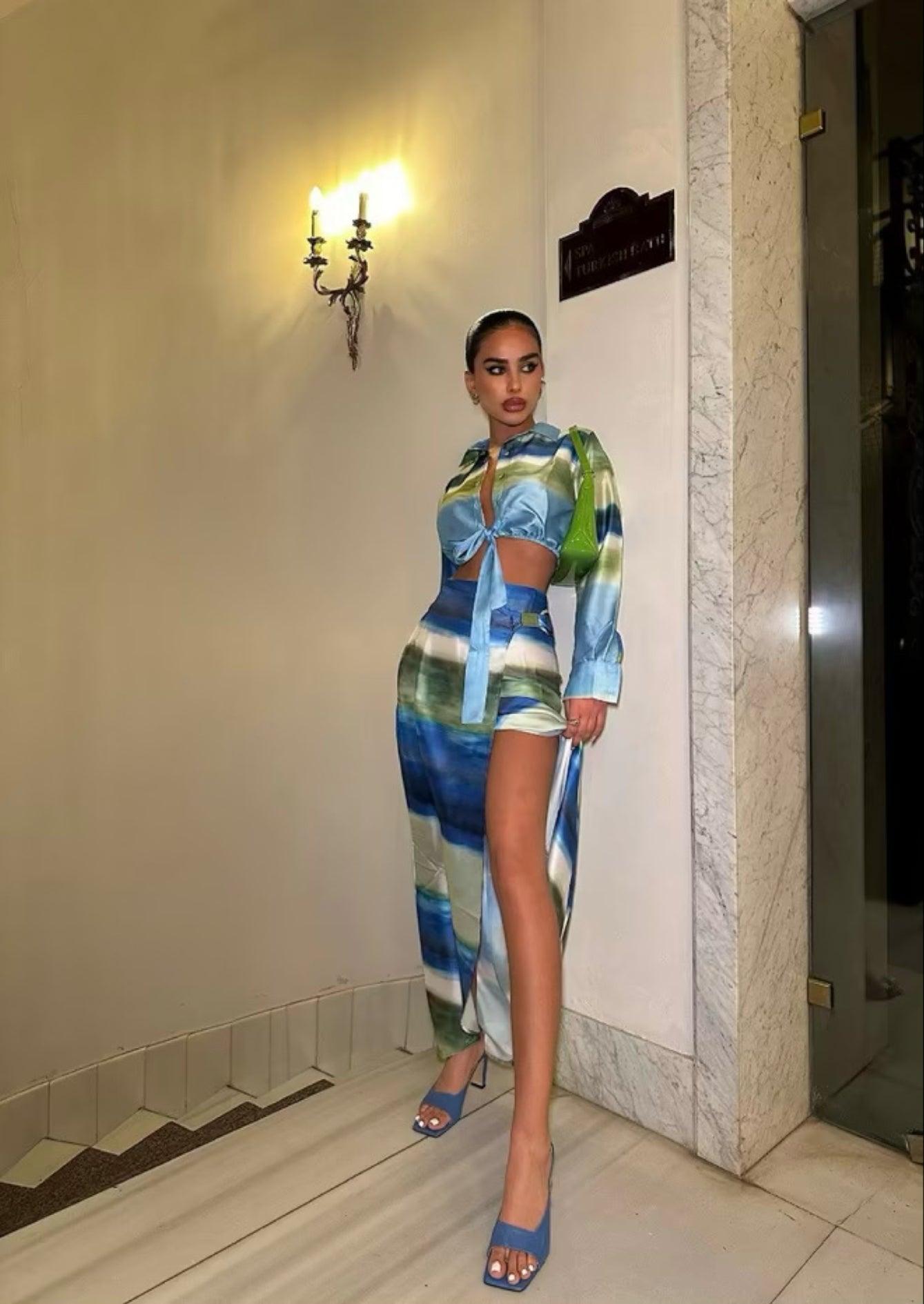 Femme portant un ensemble veste nouée bleu-vert et jupe midi fendue assortie