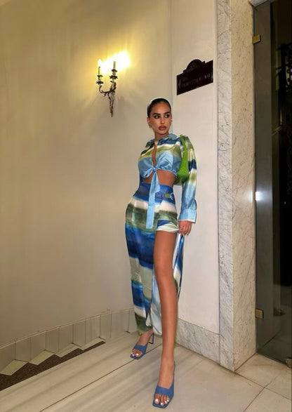 Femme portant un ensemble veste nouée bleu-vert et jupe midi fendue assortie