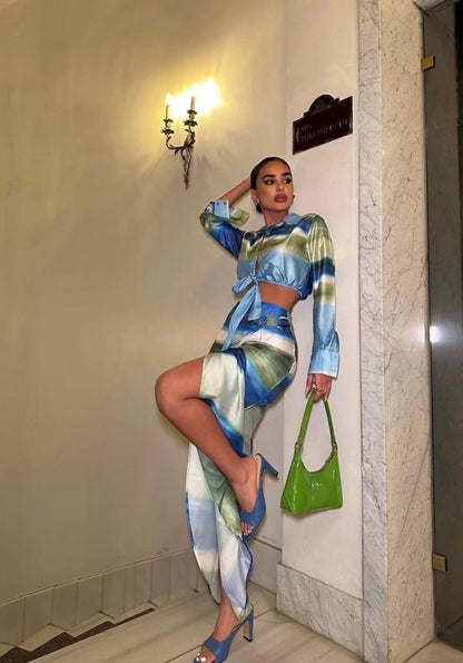 Femme portant un ensemble veste nouée bleu-vert et jupe midi fendue assortie