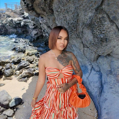Femme portant un ensemble jupe longue orange à motifs multicolores avec haut assorti sans manches 