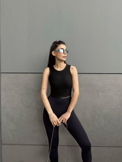 Top noir col halter en maille côtelée porté par une femme (modèle Haut Nilya)