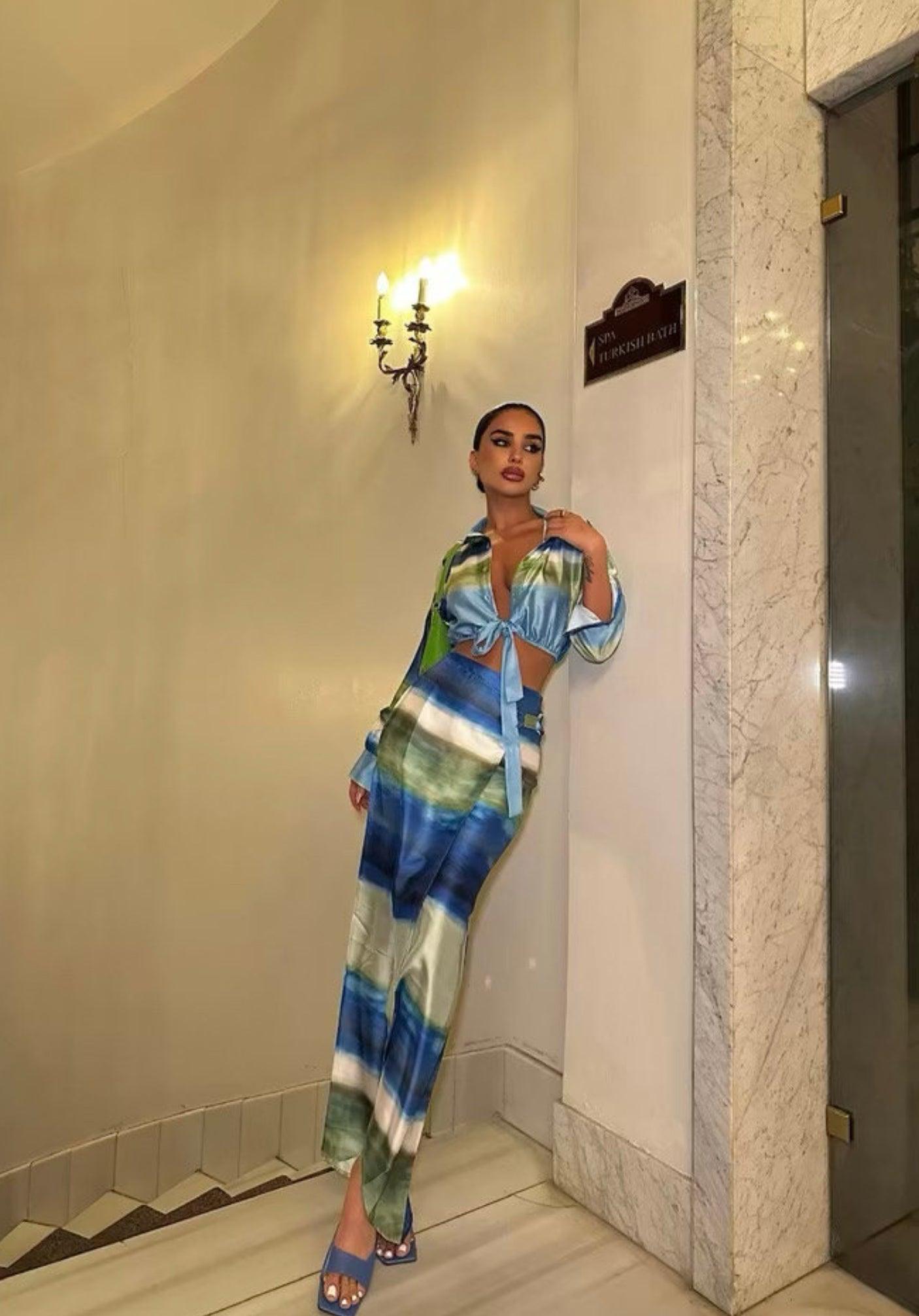 Femme portant un ensemble veste nouée bleu-vert et jupe midi fendue assortie